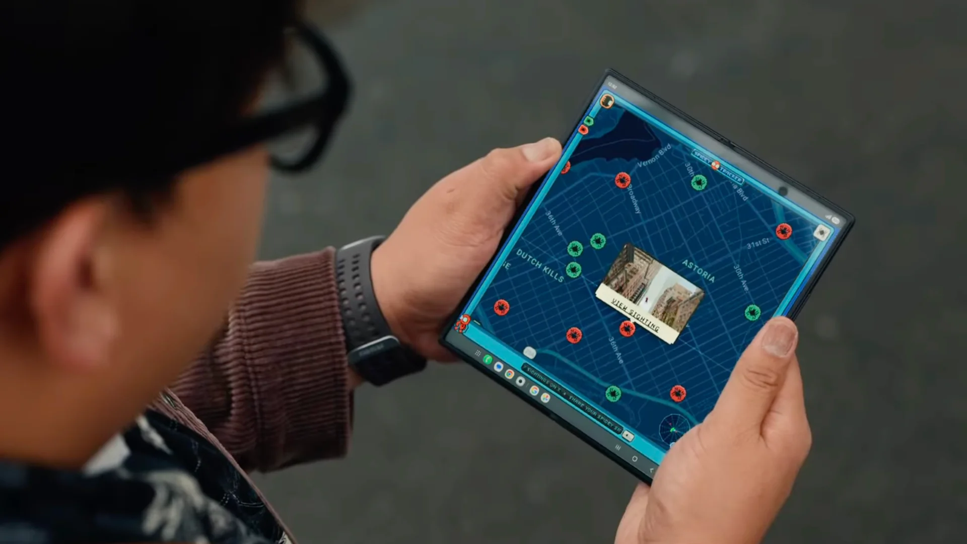 Ned Lids drži rasklopljeni Samsung Galaxy Z Fold8 Ultra sa mapom za praćenje Spider-Mana na velikom ekranu