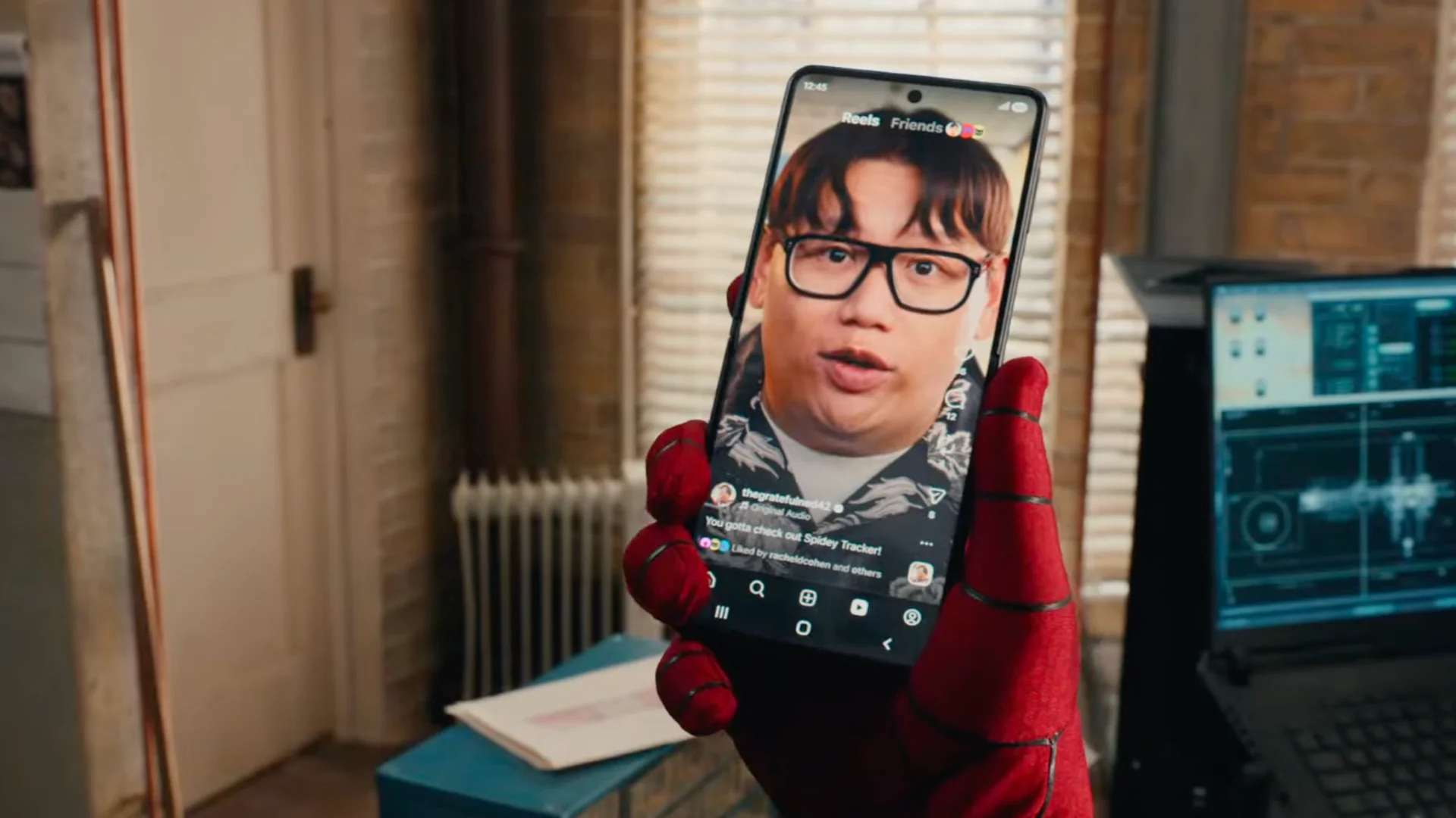 Spider-Man drži rasklopljeni Samsung Galaxy Z Flip8, dok se na ekranu prikazuje snimak Neda Lidsa