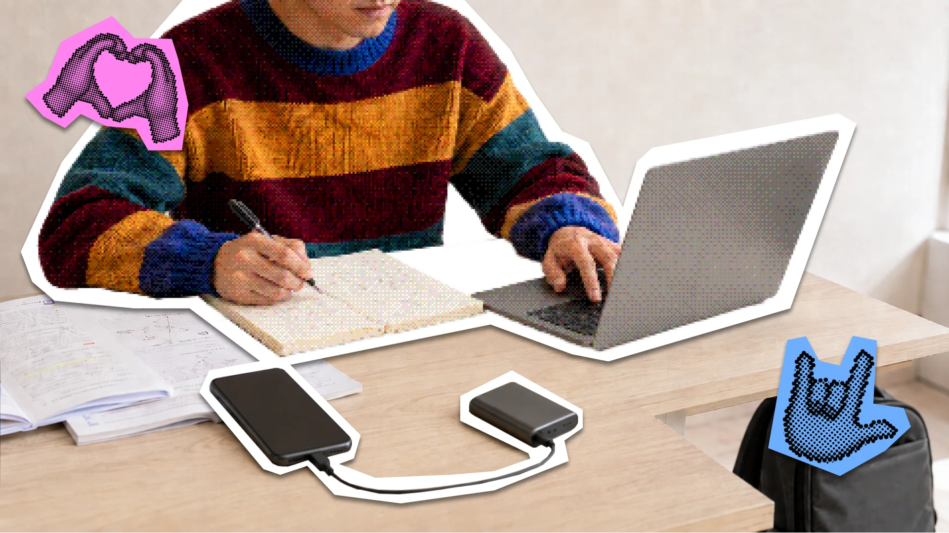 A student working on a laptop while a smartphone charges from a power bank on the desk